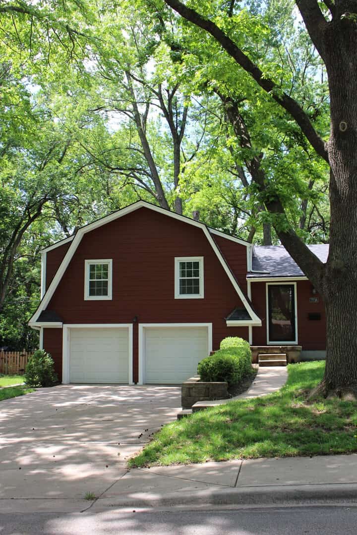 Red siding home with white trim and garage doors in Prairie Village, KS.