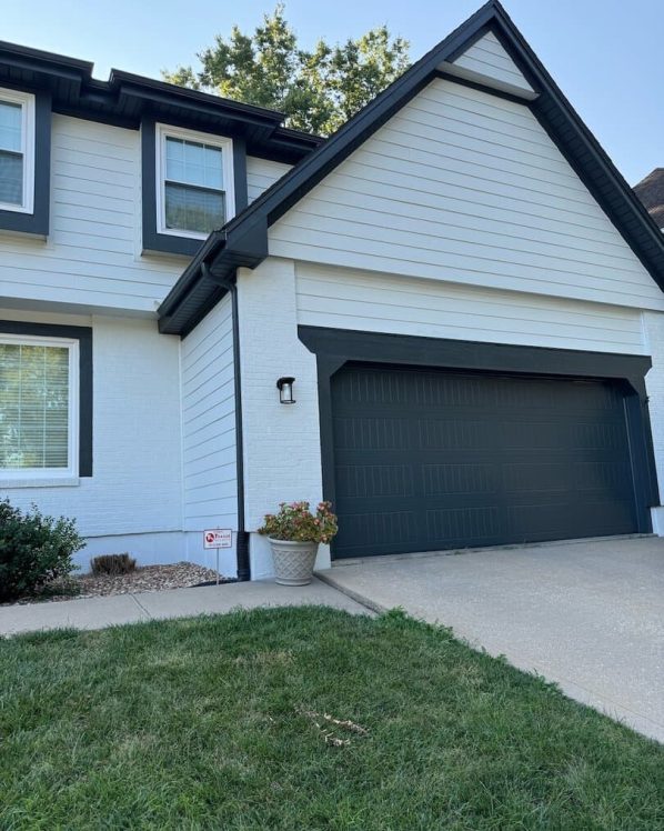Kansas City exterior home with white siding and dark garage door.